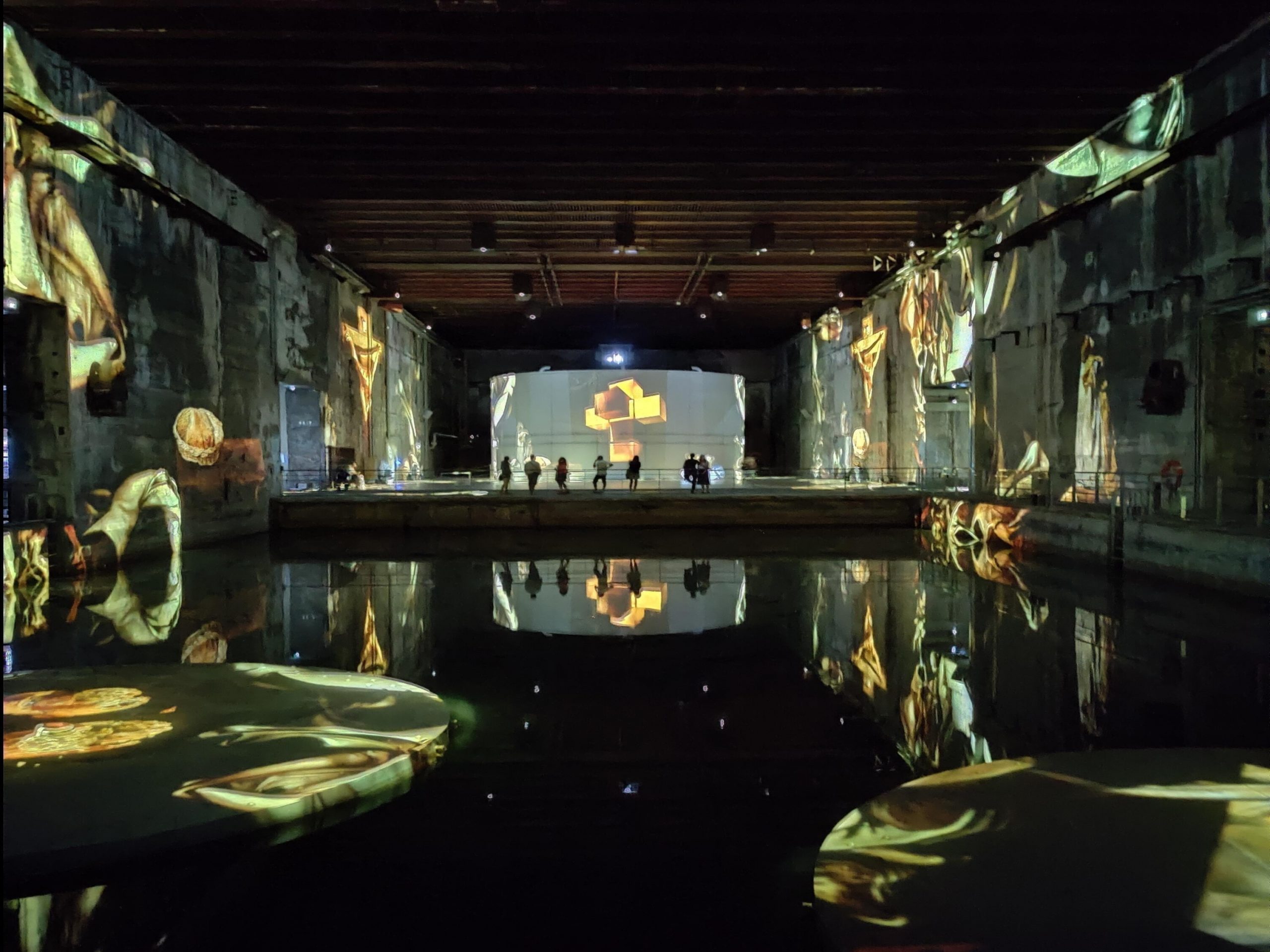Bassins des Lumières - Immersive Dali exhibition in submarine base with animated images projected across walls and water.
