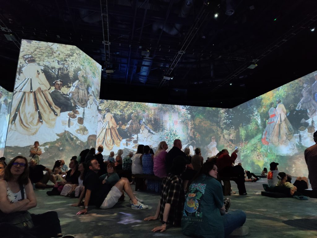 Immersive Monet exhibition in Nottingham arena with animated images projected across walls.